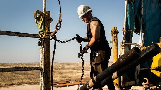 Một công nhân chuẩn bị để nâng các khoan bằng ròng rọc trong lưu vực Permian bên ngoài Midland, Texas.