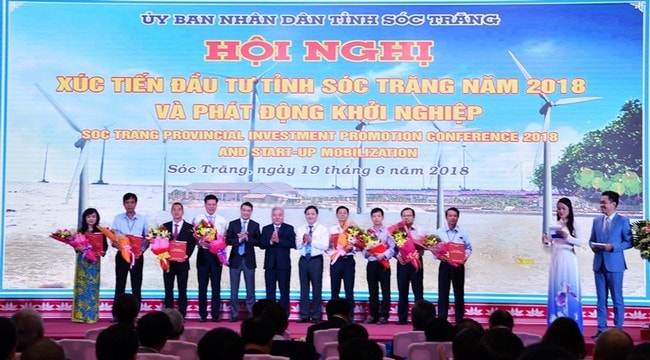 Thống đốc NHNN Lê Minh Hưng (thứ 5 từ trái sang) tặng hoa chúc mừng các ngân hàng trao văn bản cam kết tín dụng cho doanh nghiệp (Trong ảnh: Phó Tổng Giám đốc Vietcombank Phạm Mạnh Thắng (thứ 4 từ trái sang) trao văn bản cam kết tín dụng cho 3 doanh nghiệp của tỉnh Sóc Trăng)