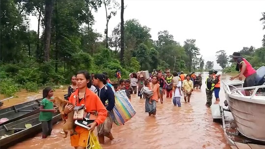 Người dân được sơ tán đến nơi an toàn sau vụ vỡ đập. Ảnh: Reuters