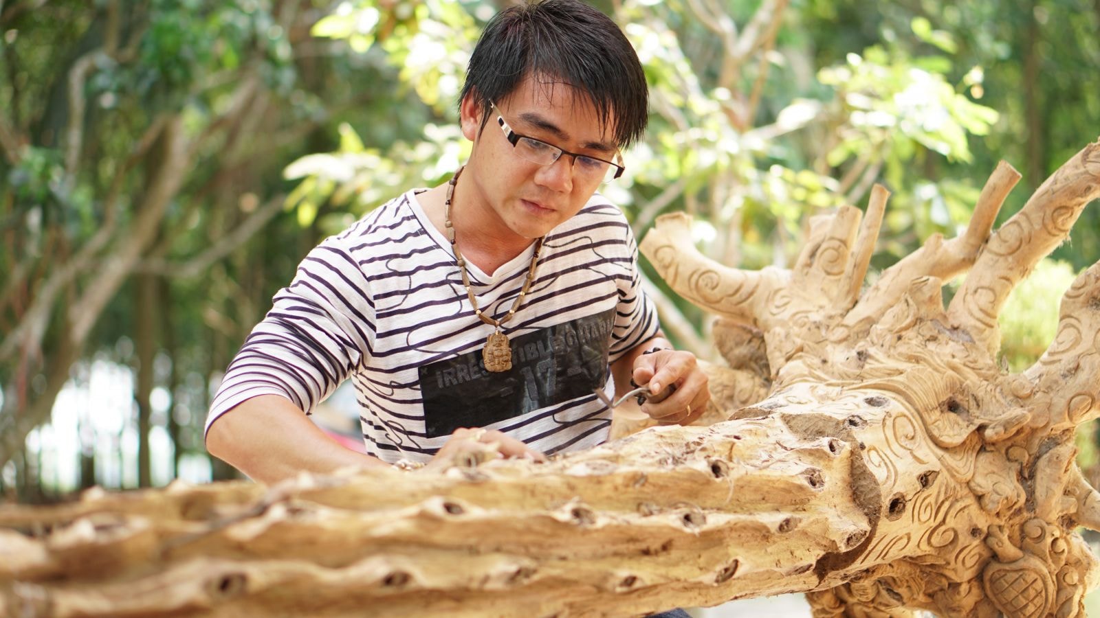 Anh Nguyễn Văn Quang đang chế tác một cây gió bầu có trầm hương.