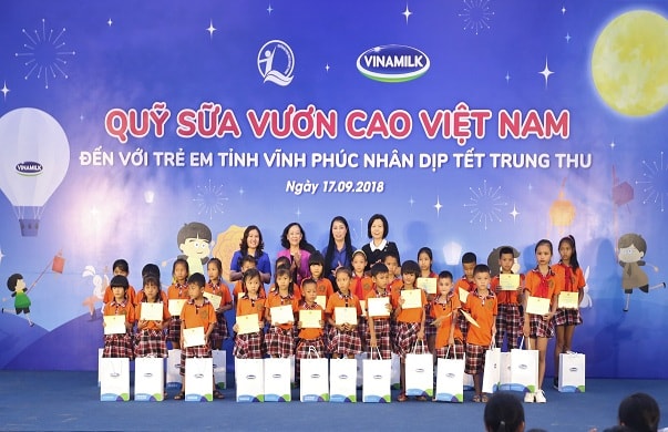 Bà Trương Thị Mai - Uỷ viên Bộ chính trị, bí thư Trung ương Đảng, trưởng ban dân vận Trung ương; bà Nguyễn Thị Hà - Thứ trưởng Bộ Lao động - Thương Binh và Xã hội; bà Hoàng Thị Thuý Lan - bí thư tỉnh uỷ Vĩnh Phúc và bà Bùi Thị Hương - Giám đốc Điều hành Vinamilk trao quà và sữa cho các em học sinh.