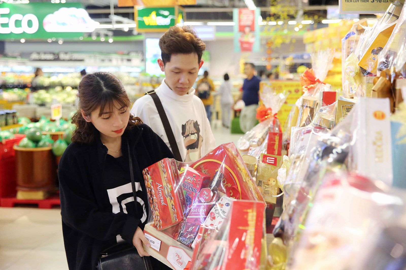 Một đôi vợ chồng trẻ đang lựa chọn giỏ quà Tết phù hợp để biếu gia đình nội, ngoại 2 bên. Các loại giỏ quà Tết tại VinMart có giá từ bình dân 199.000 đồng đến cao cấp 2 triệu đồng phong phú chủng loại, từ giỏ quà bánh kẹo truyền thống cho đến các giỏ quà phong thuỷ độc đáo nên thu hút rất nhiều khách hàng.