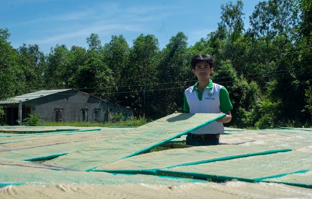 Dương Ngọc Ảnh bên những vỉ phở sắn vừa ra lò đang được phơi nắng