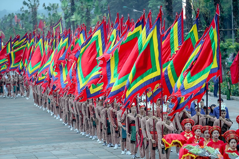 Đi sau là các thiếu nữ mang hương, hoa, lễ vật và 100 thanh niên tượng trưng cho con Lạc, cháu Hồng trong trang phục cổ, tay giương cao cờ hội, thể hiện sức sống mãnh liệt của dòng giống Tiên Rồng.