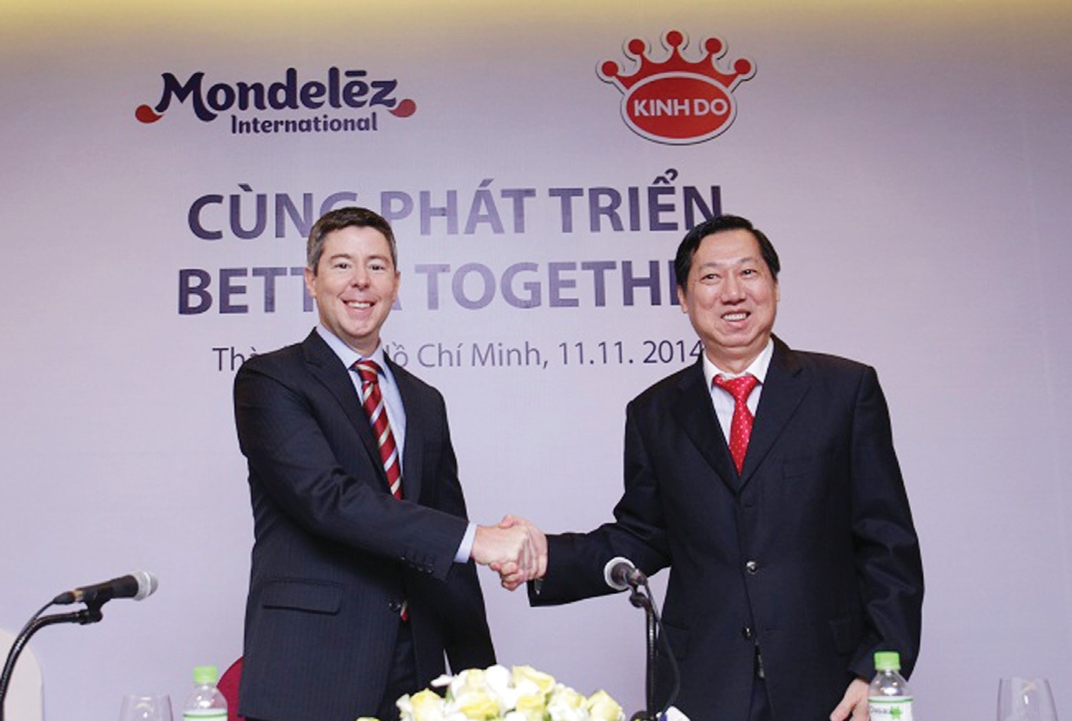 Ông Trần Kim Thanh (phải) và ông Tim Cofer của Mondelez International bắt tay sau khi ký kết hợp tác đầu tư. Ảnh: Hùng Lê.