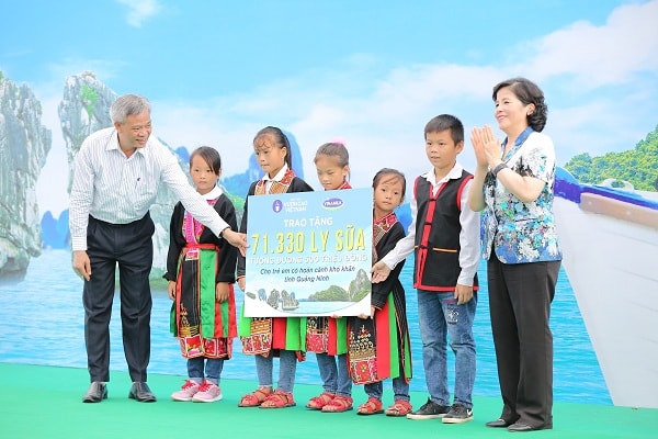 Bà Mai Kiều Liên - Thành viên Hội đồng Quản trị, Tổng Giám đốc Công ty Vinamilk trao tặng bảng tượng trưng 71.330 ly sữa, tương đương 500 triệu đồng cho các em học sinh nghèo vượt khó tỉnh Quảng Ninh. 