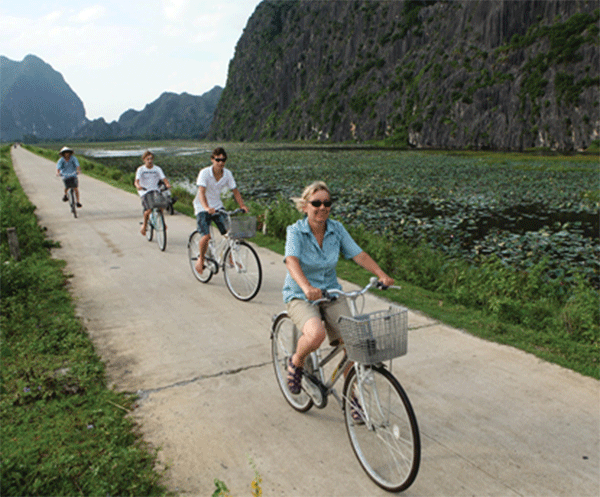 Du khách đi xe đạp khám phá ven vịnh Vân Long.