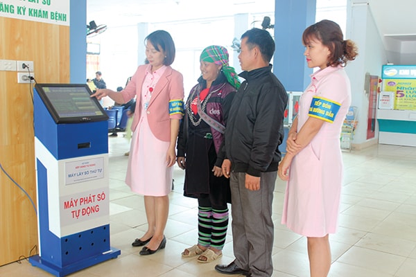 p/Nhân viên Tổ công tác xã hội hướng dẫn bệnh nhân lấy số tự động.