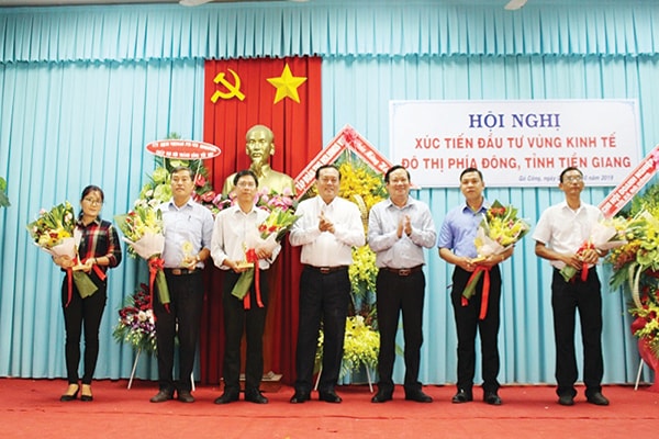 p/Phó Chủ tịch Thường trực UBND tỉnh Lê Văn Nghĩa (ở giữa) tặng hoa cho những doanh nghiệp có đóng góp phát triển vùng kinh tế phía Đông tỉnh Tiền Giang