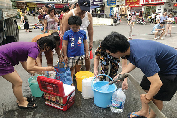 p/Người dân Hà Nội phải xếp hàng mua nước trong thời gian chờ nhà máy Sông Đà xúc xả đường ống – Ảnh: T.T.