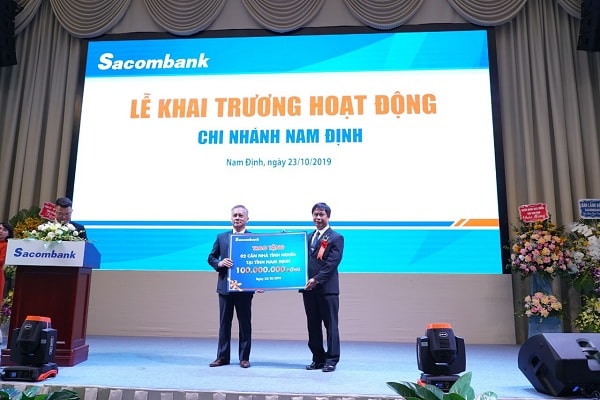 Đại diện Sacombank – ông Phan Đình Tuệ - Bí thư Đảng ủy, Phó Tổng giám đốc kiêm Chủ tịch Công đoàn cơ sở trao biểu trưng 2 căn nhà tình nghĩa cho đại diện tỉnh Nam Định, Ông Phạm Minh Phương – Chủ tịch Hội chữ thập đỏ Tỉnh Nam Định