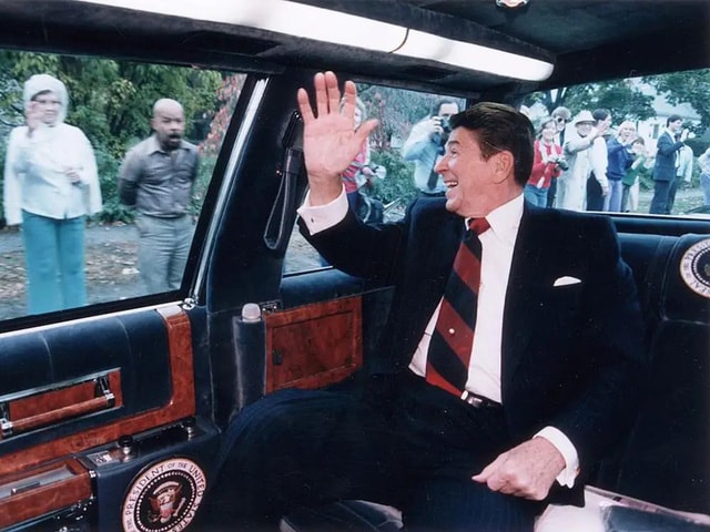 Tổng thống Hoa Kỳ Ronald Reagan vẫy tay từ trong chiếc limousine của mình trên đường một điểm dừng chiến dịch ở Fairfield, Connecticut, ngày 26 tháng 10 năm 1984. (Nguồn: Business Insider)