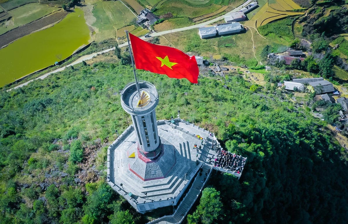 Cuối ngày thứ hai trong hành trình chinh phục miền biên ải, hơn 300 VinFaster đã cũng chung nhịp đập trái tim khi chứng kiến khoảng khắc lá cờ Việt Nam tung bay trên cột cờ Lũng Cú. Tại đây, đại diện VinFast đã trao tặng Đồn biên phòng Lũng Cú quốc kỳ rộng 54m2 - tượng trưng cho 54 dân tộc anh em, cũng là lá cờ lớn nhất Việt Nam. VinFast cũng đã trao tặng 3 suất học bổng cho các cháu có hoàn cảnh khó khăn được Đồn biên phòng Lũng Cú nhận làm con nuôi.