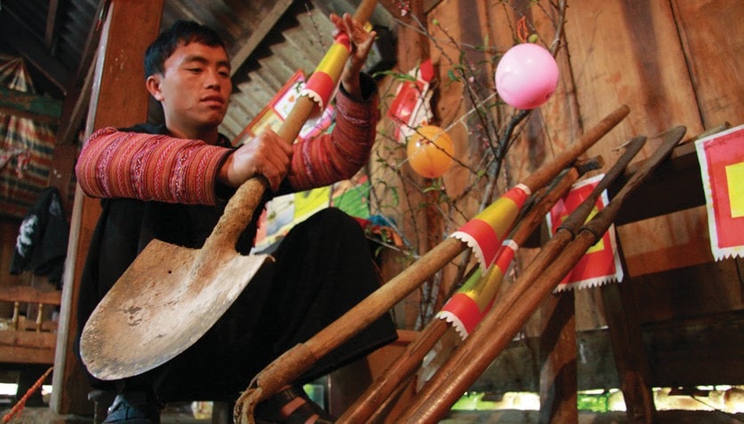 Người Mông ở Mù Căng Chải thường dán giấy lên công cụ lao động và đưa lên bàn thờ trong ba ngày Tết để cảm ơn vì đã phục vụ con người vất vả trong năm qua