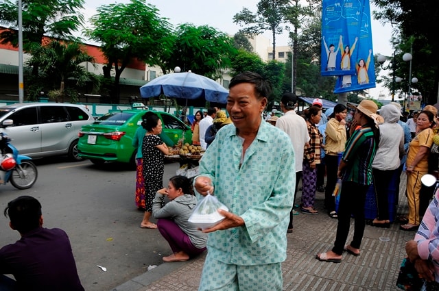 Nụ cười nở trên môi người nhà và bệnh nhân khi nhận được suất cơm từ thiện.