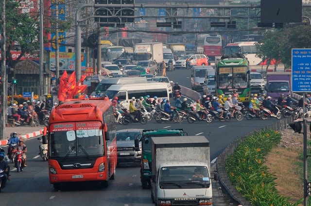 Quốc lộ 1A đoạn gần vòng xoay An Lạc, quận Bình Tân chất cứng các loại phương tiện. Lực lượng CSGT phải vất vả để điều tiết giao thông.