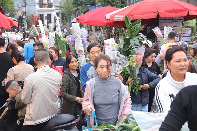 Để tránh gãy hoa khi chen lấn, ai cũng cố giơ thật cao bó hoa của mình.