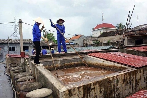 Công nhân công ty TNHH Quang Hải đang đánh quậy phơi nắng tại các bể ủ chượp