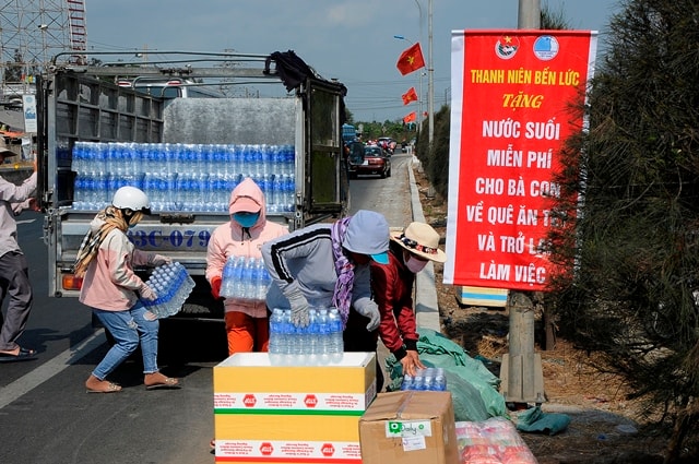 Anh Duy chọn gần cầu Bến Lức để phát nước cho người đi đường vì theo anh khu vực này xa nhà dân và không ảnh hưởng đến hoạt động buôn bán của bà con ven đường.