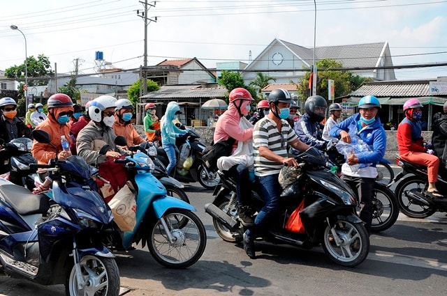 Anh Lê Duy (áo xanh) vừa phát nước vừa nhắc nhở người đi đường đi sát vào lề nhận nước để tránh gây cản trở giao thông.