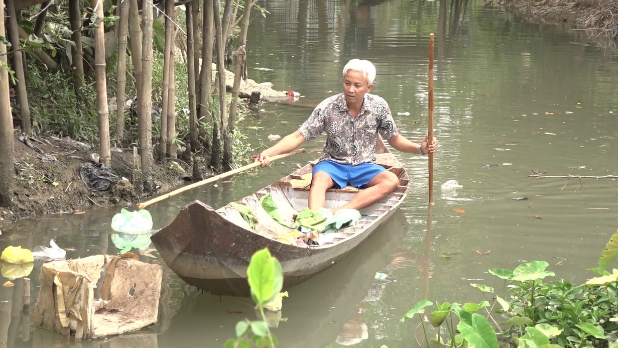 Ông Minh hàng ngày bơi xuồng đi vớt rác trả lại sự thông thoáng cho con kênh