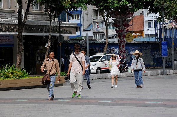 Một nhóm bạn trẻ người Việt Nam dạo chơi và chụp hình trên phố đi bộ Nguyễn Huệ cũng không đeo khẩu trang.