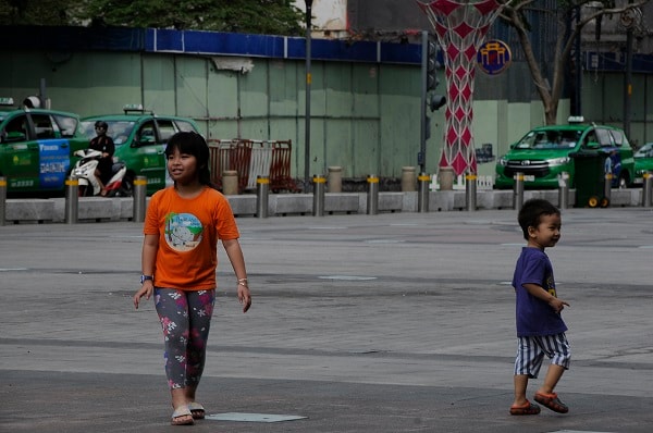 Các em nhỏ nô đùa trên Phố đi bộ Nguyễn Huệ cũng không được cha mẹ trang bị Khẩu trang phòng dịch.