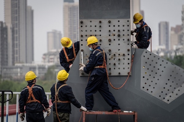 Các hoạt động sản xuất đang dần được khôi phục trở lại. Những người công nhân làm việc lại trên các công trình tại Vũ Hán, Trung Quốc. Ảnh: Reuters