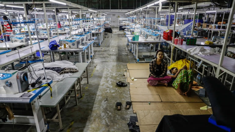 ông nhân đình công tại một nhà máy may gần đây đã đóng cửa gần Yangon, Myanmar để yêu cầu nhà máy trả lương và tiền làm thêm giờ 