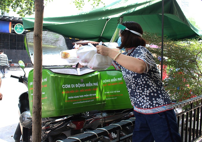 10h30, tình nguyện viên cho cơm vào thùng để chở đi phát. 