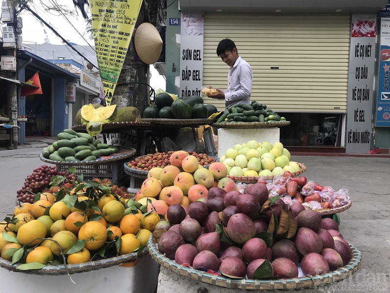 Hình ảnh người bán hàng hoa quả đang rất rạng rỡ khi có người mua hàng cho mình.