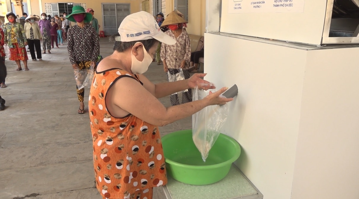Những người có hoàn cảnh khó khăn đến nhận gạo miễn phí tại các cây ATM gạo
