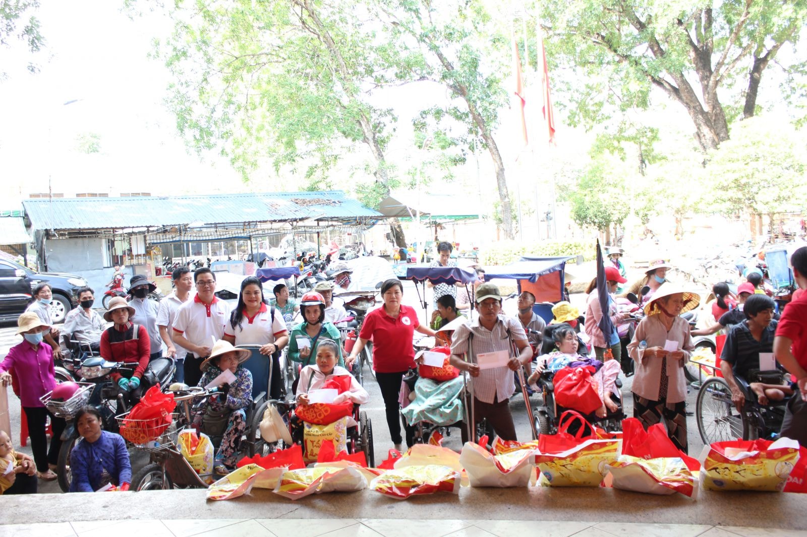 Đại diện Vedan và đại diện Hội Chữ thập đỏ huyện Long Thành trao quà cho người dân khuyết tật trên địa bàn