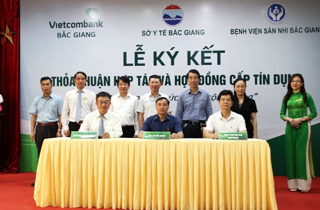 Ông Lê Hồng Tâm – Giám đốc Vietcombank Bắc Giang (hàng ngồi, ngoài cùng bên trái) ký kết thỏa thuận hợp tác với đại diện Sở Y tế và Bệnh viện Sản – Nhi Bắc Giang