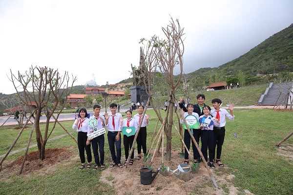 Các em học sinh trồng cây và chụp hình lưu niệm bên những cây xanh vừa trồng trong Chương trình Quỹ “1 triệu cây xanh cho Việt Nam”.