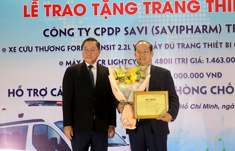 Ông Nguyễn Tấn Bỉnh, giám đốc sở Y tế thành phố trao thư cảm ơn và tặng hoa cho ông Trần Tựu – Chủ tịch hội đồng quản trị công ty SAVIPHARM