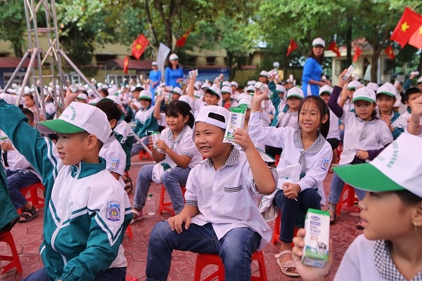 Các em học sinh Trường Tiểu học A hào hứng tham gia hoạt động uống sữa cùng các bạn tại sân trường trong buổi lễ phát động.