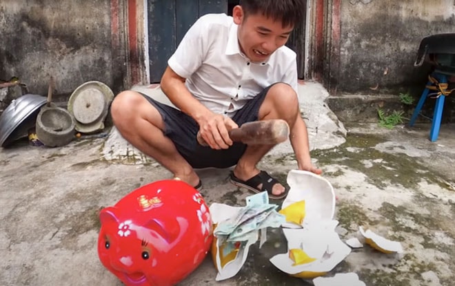 Hưng Vlog bị lên án vì làm video bày cách trộm tiền trong heo đất. Ảnh cắt từ clip.