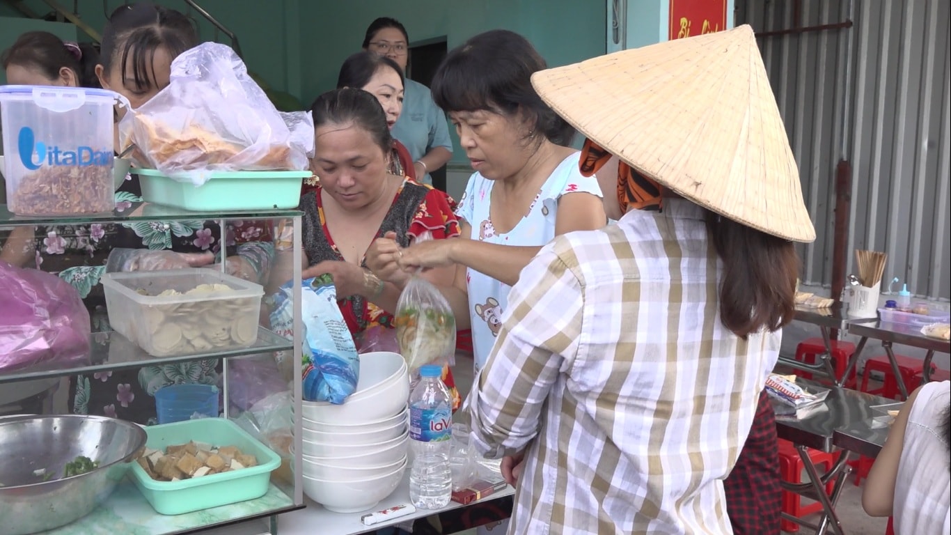 Mọi người tất bật chuẩn bị các phần ăn cho người dân đến thưởng thức và xin mang về