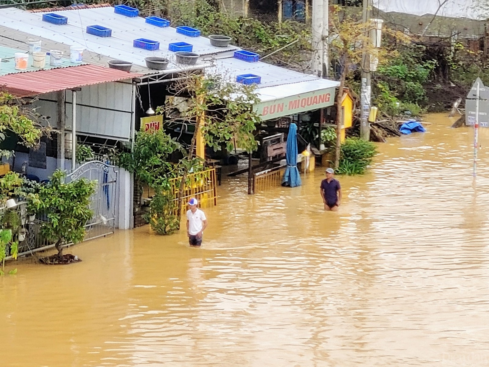 Người dân len qua dòng nước để đến nơi khô ráo.