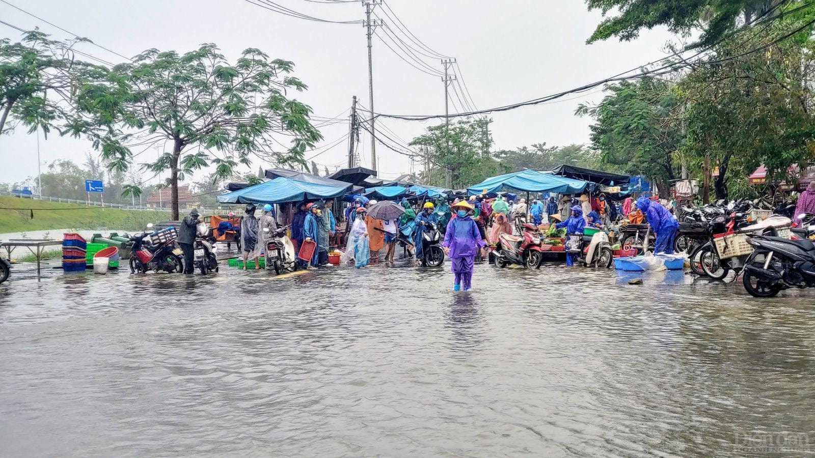 Tiểu thương tại chợ Thanh Hà dời quầy hàng đến khu vực cao hơn để tiếp tục buôn bán.