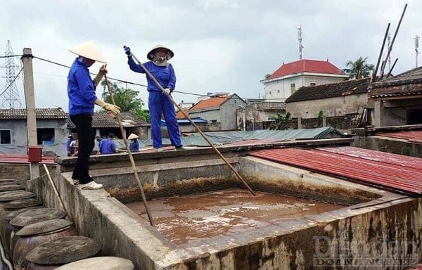 Công nhân công ty TNHH Quang Hải đang đánh quậy phơi nắng tại các bể ủ chượp