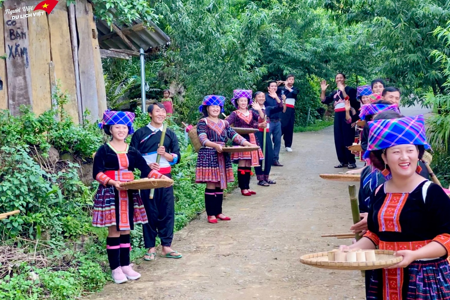  những nàng tiên váy đỏ bưng những nong tre cùng những chàng trai thổi sáo, nở trên mặt họ là những nụ cười tươi với hàm răng trắng