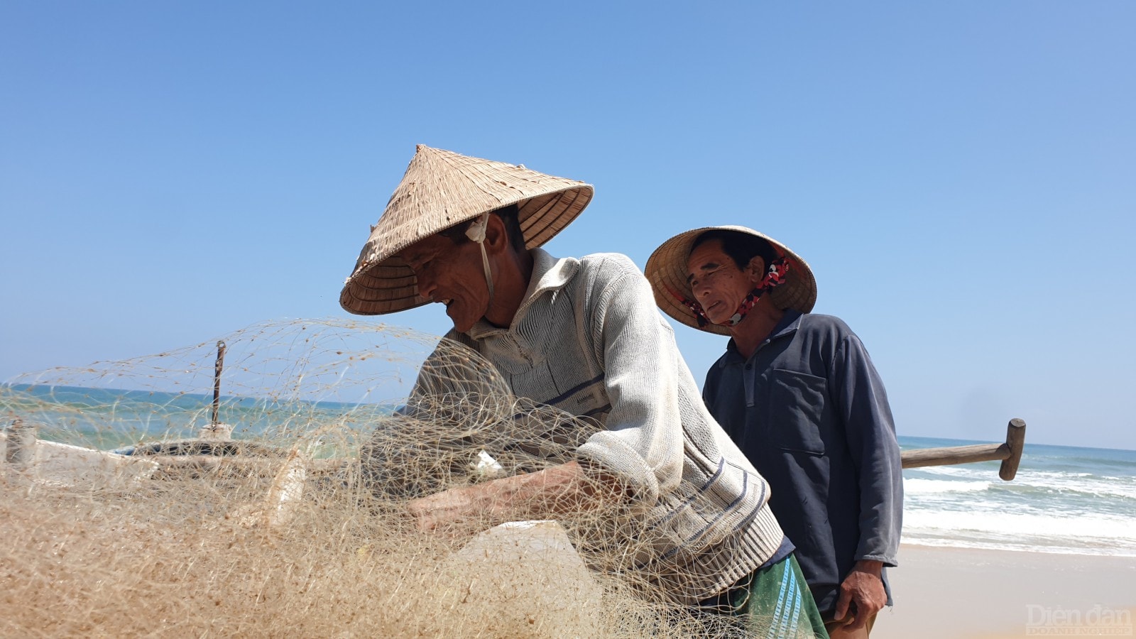 Ngư dân làm sạch lưới để tiếp tục đánh bắt vào hôm sau.