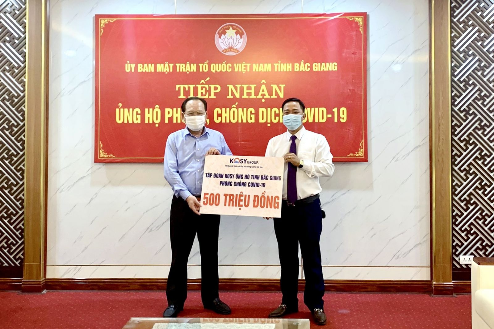 Ông Nguyễn Văn Sơn – Giám đốc Ban Quản lý dự án các khu đô thị của Tập đoàn Kosy tại Bắc Giang (bên phải) trao 500 triệu đồng ủng hộ công tác phòng chống dịch Covid-19 cho ông Trần Công Thắng – Chủ tịch Ủy ban Mặt trận Tổ quốc tỉnhp/Bắc Giang (bên trái).