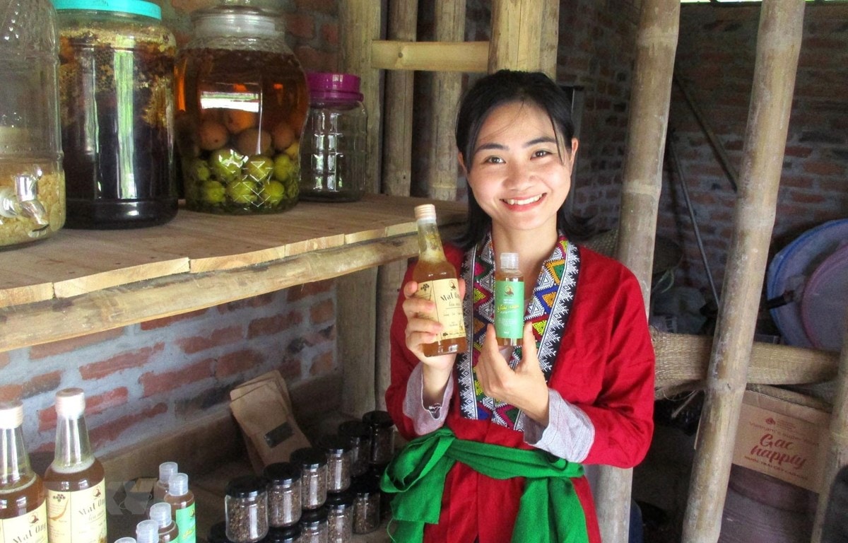 Chi Nguyễn Lê Ngọc Linh và sản phẩm mật ong sạch của Vườn rừng bản Thổ. (Ảnh: Nguyễn Nam/TTXVN)