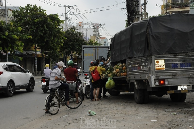 Hàng rong vẫn bày bán trên vỉa hè, thu hút nhiều người mua, không đảm bảo giãn cách theo Chỉ thị 16. (Ảnh chụp trên đường Nguyễn Ảnh Thủ, Q.12).