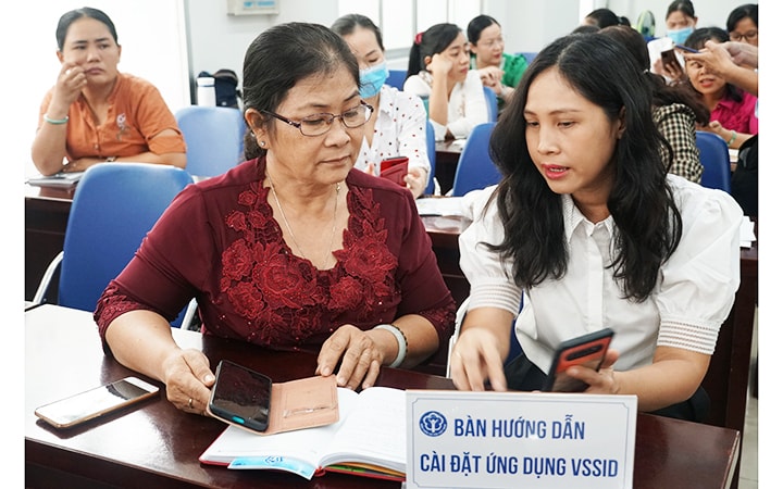 Cán bộ BHXH thành phố Hồ Chí Minh tư vấn, hướng dẫn người dân cài đặt và sử dụng ứng dụng VssID