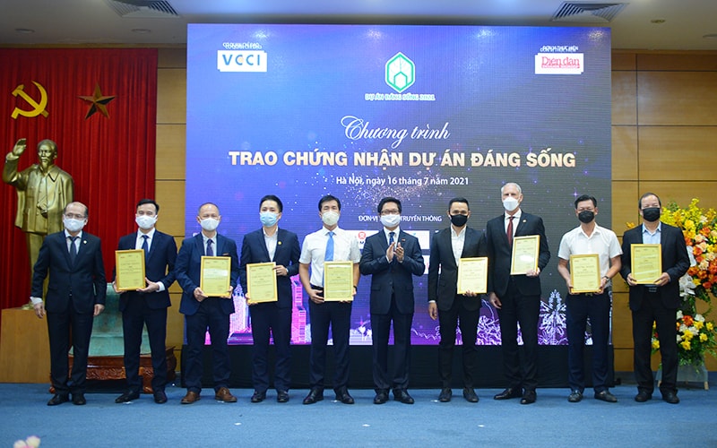 Tiến sỹ Vũ Tiến Lộc – Chủ tịch Phòng Thương mại và Công nghiệp Việt Nam (VCCI) và Nhà báo Phạm Ngọc Tuấn – Tổng biên tập Tạp chí Diễn đàn Doanh nghiệp trao chứng nhận và kỷ niệm chương cho các đại diện các nhà phát triển dự án nhận chứng nhận Nhà phát triển dự án đáng sống 2021: Ông Mark Reevess - Giám đốc Thương hiệu Sáng tạo Tập đoàn BRG; Ông Nguyễn Anh Tuấn - Phó Chủ tịch HĐQT HD Mon Holdings; Ông Thân Thế Hà – Chủ tịch Hội đồng thành viên Splendora JVC; Ông Phạm Hải Đăng – Phó Tổng Giám đốc Tập đoàn GFS; Ông Dennis Ng Teck Yow – Tổng Giám đốc Gamuda Land Vietnam; Ông Nguyễn Tuấn Hoàng – Tổng Giám đốc Công ty Cổ phần Bất động sản Hoa Anh Đào; Ông Nguyễn Văn Hải – Giám đốc Khối Dịch vụ Khách hàng Tập đoàn MIKGroup; Ông Đỗ Văn Kiên – Tổng Giám đốc Tập đoàn Hưng Thịnh Hà Nội; Ông Nguyễn Viết Tạo, Đại diện Hội đồng Quản trị Công ty Cổ phần Du lịch Mỹ An.