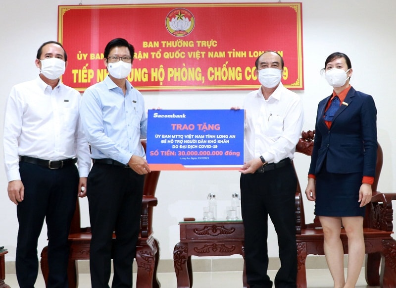 Đại diện Sacombank - ông Trần Minh Tâm, Giám đốc Chi nhánh Long An (bên trái), trao tặng 30 tỷ đồng cho Ủy ban Mặt trận Tổ quốc VN tại Long An để hỗ trợ người dân khó khăn do Covid-19.